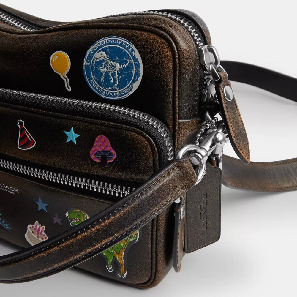 Geantă crossbody Dakota „Rexy 10Th Birthday” din piele uzată, cu imprimeu de autocolante